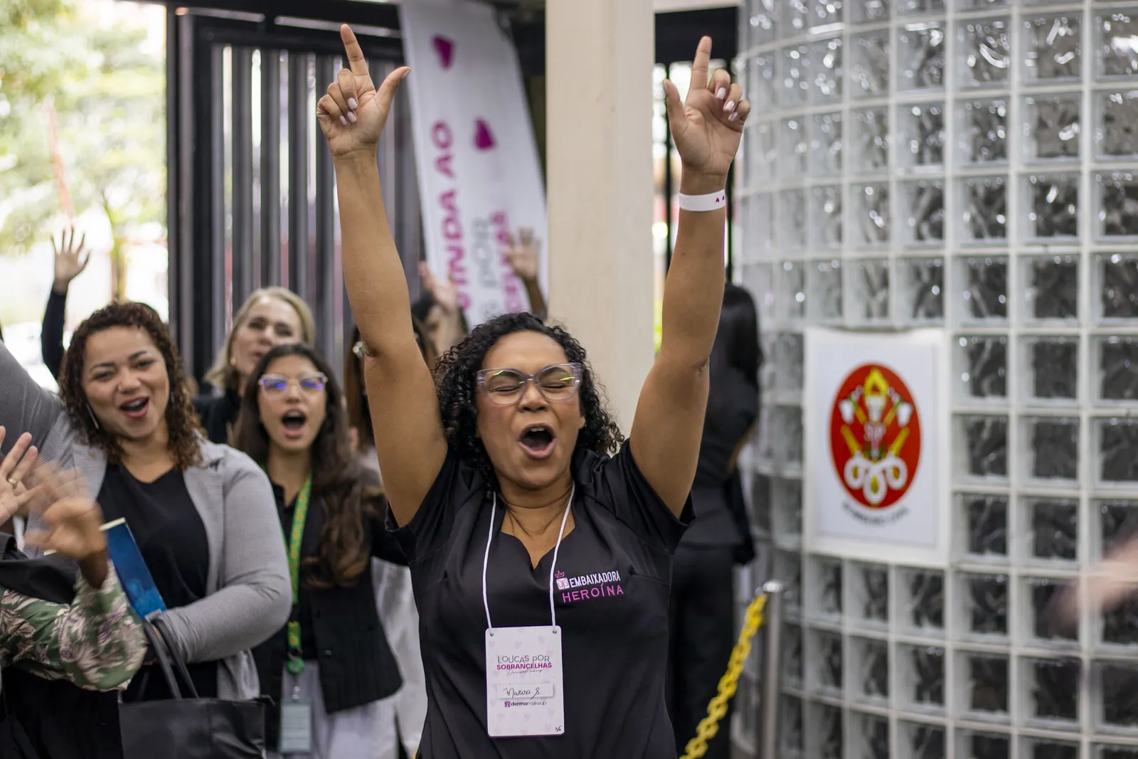 Participante comemorando de braços abertos na entrada do evento